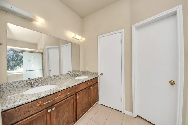 a bathroom with a granite countertop sink and a mirror