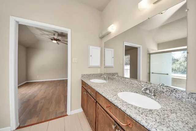 a bathroom with a granite countertop sink and a mirror
