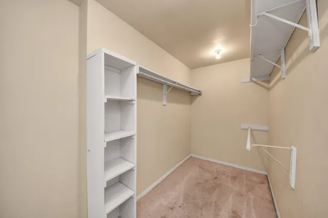 a view of walk in closet with empty racks