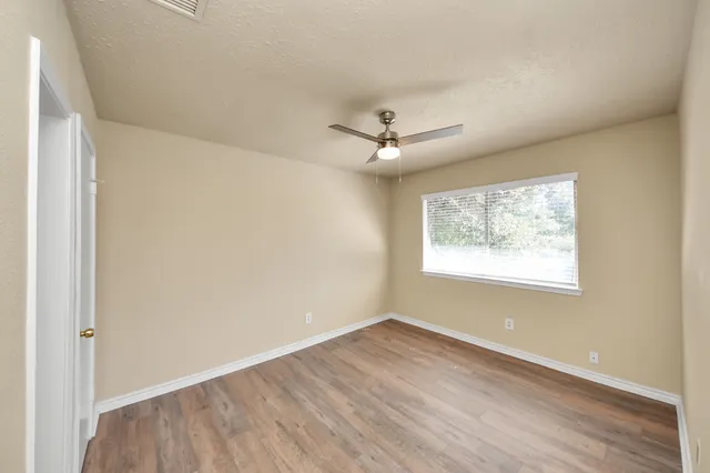 wooden floor in an empty room with a window
