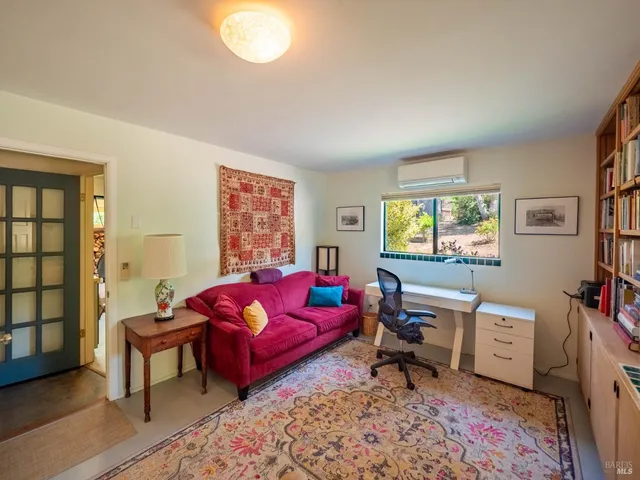 a living room with furniture a rug and a window