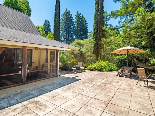 a patio with a table and chairs under an umbrella