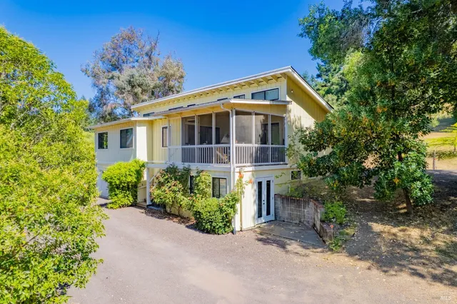 a front view of a house with a yard and trees