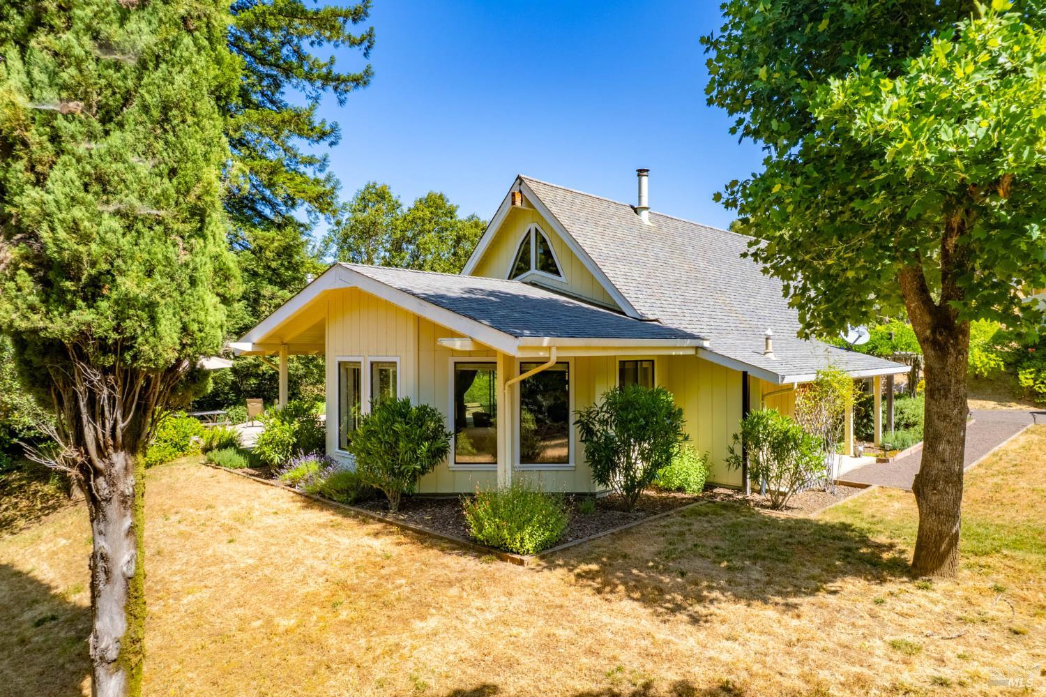 2151 Highway 128 Philo, CA 95466 - Photo 3 of 55 a view of a white house next to a yard with big trees and plants