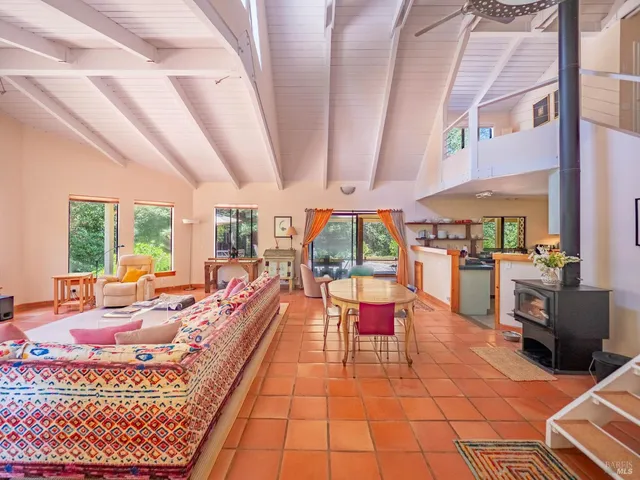 a living room with furniture a fireplace and large windows