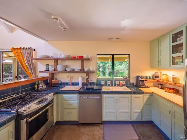 a kitchen with a stove a sink and a window