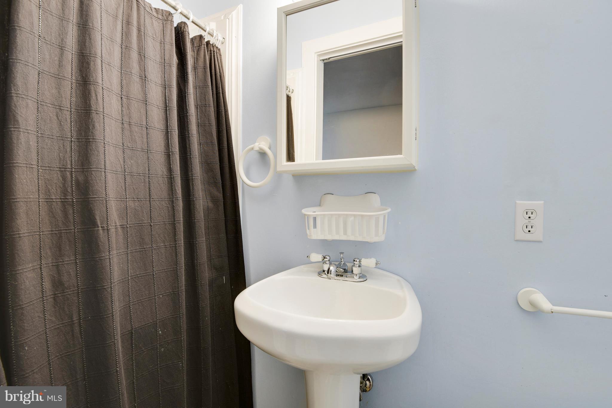 5734 Swamp Circle Road Deale, MD 20751 - Photo 17 of 30 a bathroom with a sink a mirror and shower