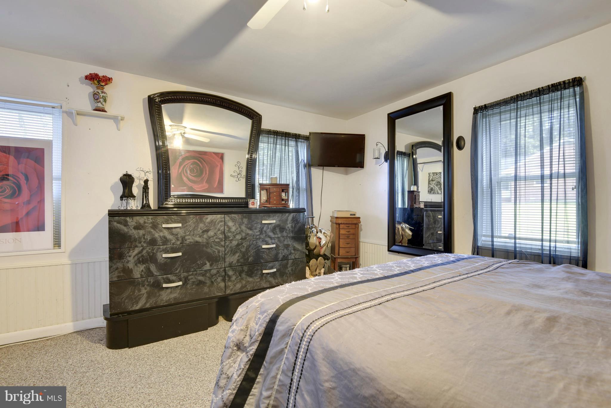 5734 Swamp Circle Road Deale, MD 20751 - Photo 23 of 30 a bedroom with a large bed and a mirror on dresser