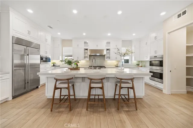 a kitchen with a dining table chairs refrigerator and cabinets