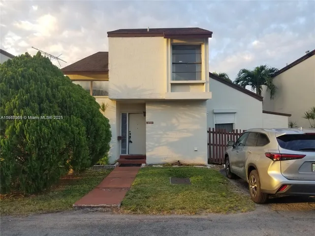 a couple of cars parked in front of a house