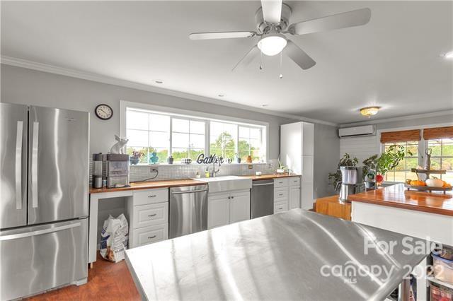 945 Field Trial Road Camden, SC 29020 - Photo 10 of 19 a kitchen with stainless steel appliances granite countertop a refrigerator a sink dishwasher a stove and white countertops with wooden floor