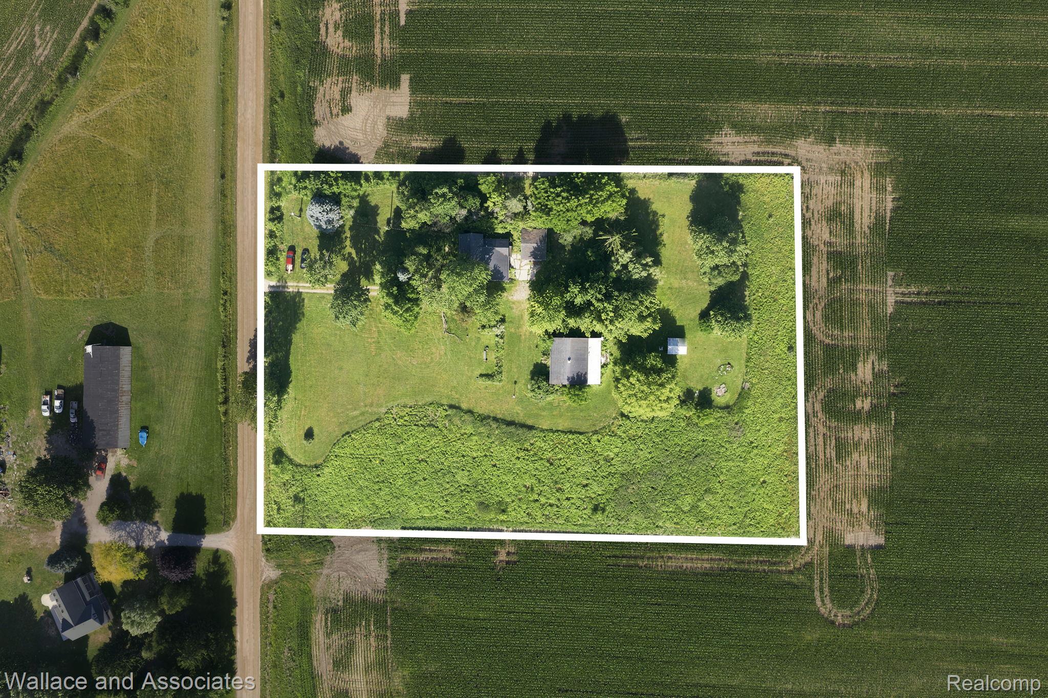 5949 Roach Road Croswell, MI 48422 - Photo 3 of 48 Aerial property view featuring a primary residence with an asphalt shingle roof, surrounded by mature trees and expansive green space