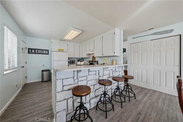 a kitchen with stainless steel appliances kitchen island wooden floors and white cabinets