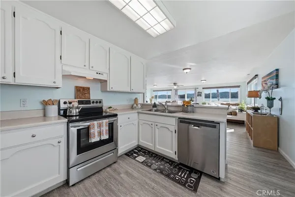 a kitchen with granite countertop a stove top oven sink and cabinets