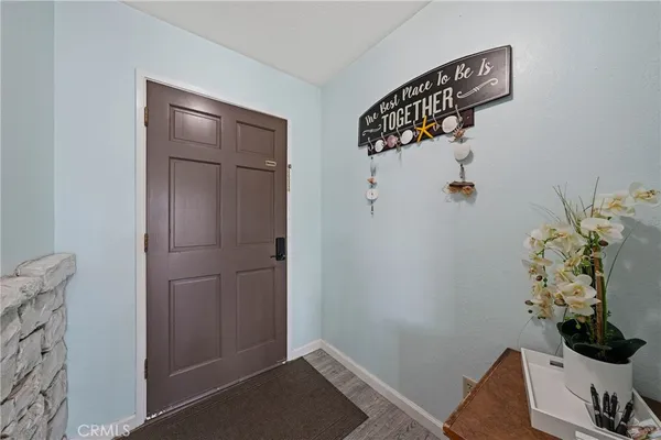 a view of a white house with large windows and a small yard