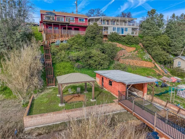 a view of a brick house with large windows and a small yard