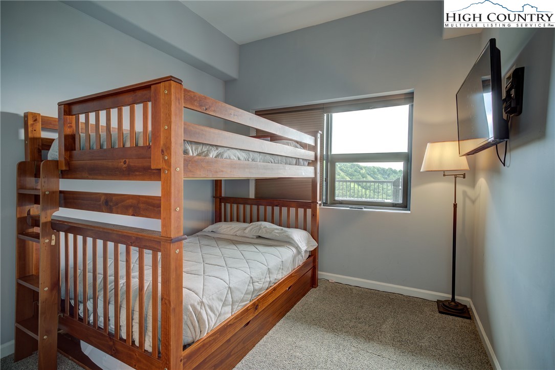 303 Sugar Top Drive, Unit 2407 Sugar Mountain, NC 28604 - Photo 13 of 36 a bedroom with a bed and a window
