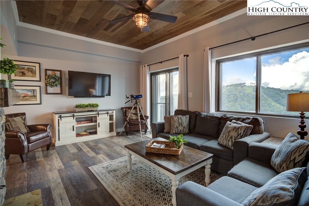 303 Sugar Top Drive, Unit 2407 Sugar Mountain, NC 28604 - Photo 2 of 36 a living room with furniture flat screen tv and a large window