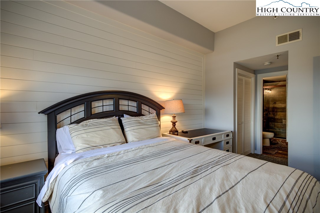 303 Sugar Top Drive, Unit 2407 Sugar Mountain, NC 28604 - Photo 10 of 36 a bedroom with a large bed and a large mirror