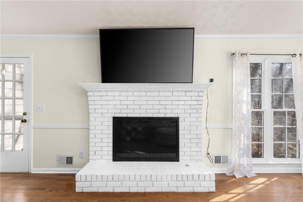 705 Springview Court Roswell, GA 30076 - Photo 13 of 79 a living room with a fireplace and a floor to ceiling window