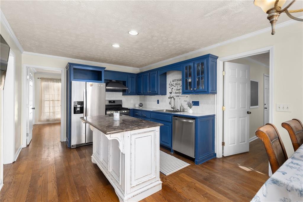 705 Springview Court Roswell, GA 30076 - Photo 19 of 79 a kitchen with stainless steel appliances granite countertop a refrigerator stove and wooden floor