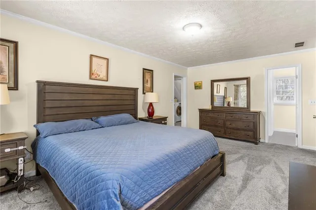 a bedroom with a bed and a flat tv screen on a dresser
