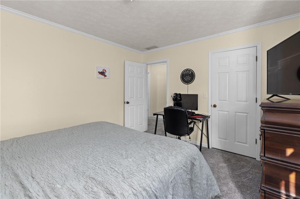 705 Springview Court Roswell, GA 30076 - Photo 54 of 79 a bedroom with a bed and a flat tv screen on a dresser