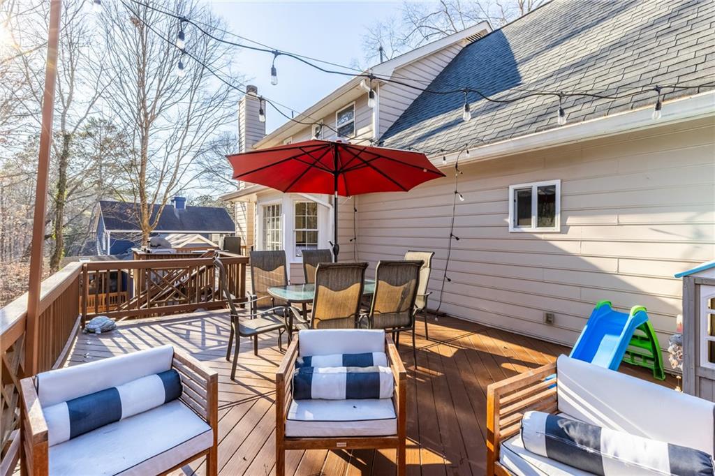 705 Springview Court Roswell, GA 30076 - Photo 67 of 79 a view of a patio with a dining table and chairs under an umbrella