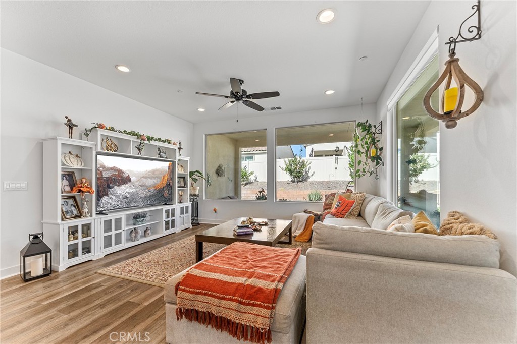 1656 Spring Run Lane Beaumont, CA 92223 - Photo 11 of 40 a living room with furniture a ceiling fan and a flat screen tv
