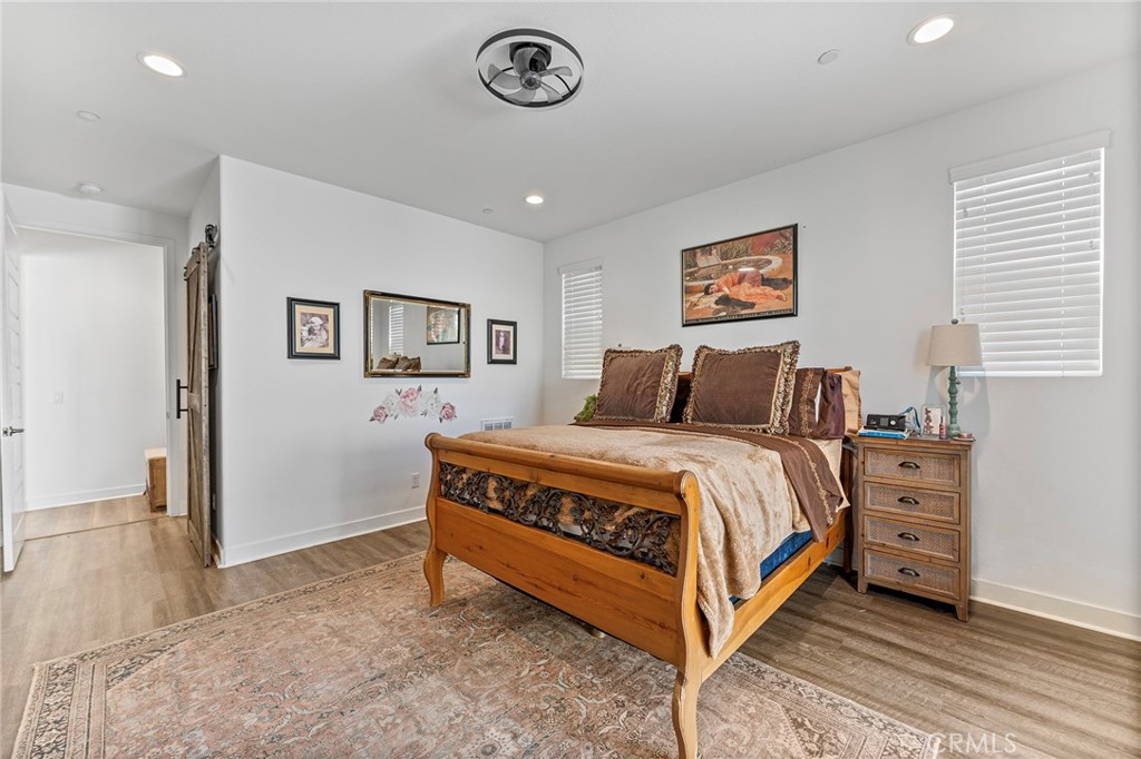 1656 Spring Run Lane Beaumont, CA 92223 - Photo 23 of 40 a bedroom with a bed and a chandelier