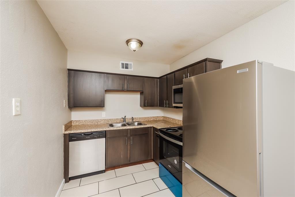 4618 Reiger Avenue, Unit 104 Dallas, TX 75246 - Photo 11 of 19 a kitchen with stainless steel appliances a refrigerator sink and stove