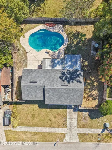 a view of an empty room with wooden floor and a ceiling fan