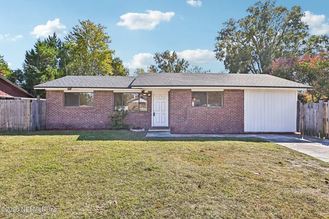 a view of a house with a backyard