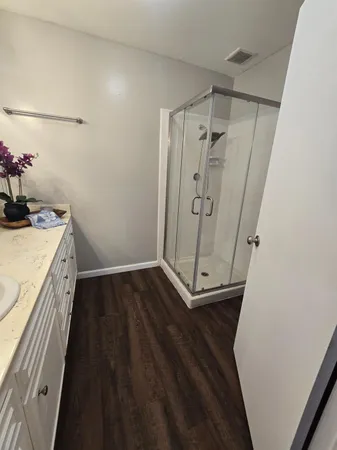 a view of a bathroom with wooden floor and a sink