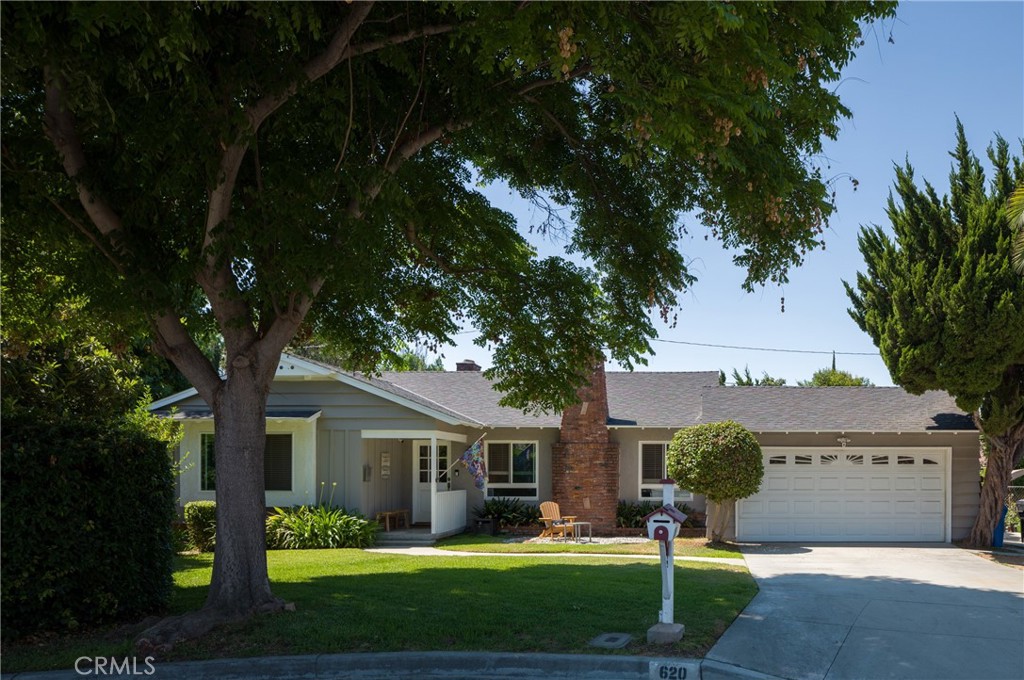 a front view of a house with a garden and yard