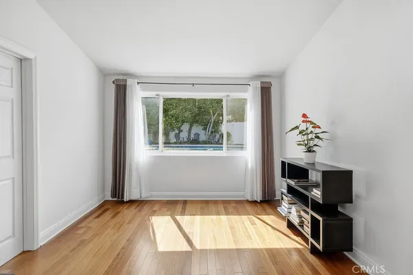 a view of an empty room with a window and a flat screen tv