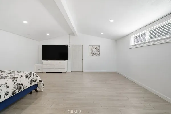 a view of bedroom with furniture and flat screen tv