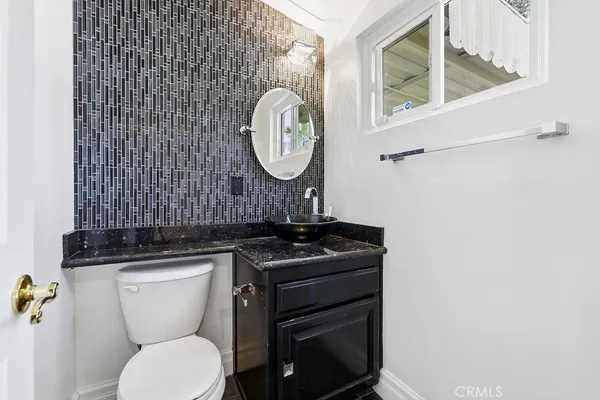 a bathroom with a toilet a sink and a mirror