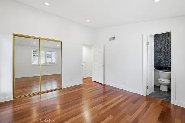 an empty room with wooden floor and bathroom