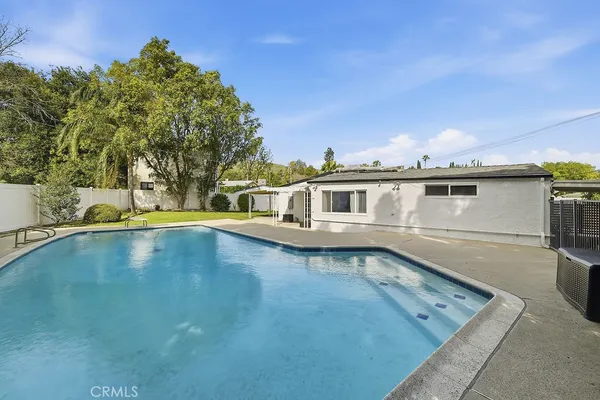 a view of a house with pool and sitting area