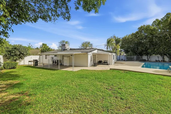 a view of house with garden and trees in the background