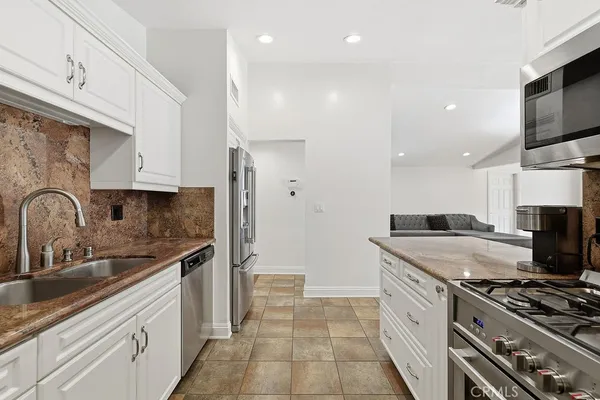a kitchen with stainless steel appliances granite countertop a sink stove and refrigerator