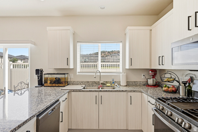 668 East Fiddlers Canyon Road, Unit 6 Cedar City, UT 84721 - Photo 8 of 36 Kitchen featuring U-shaped granite countertops, light wood-finish cabinetry, stainless steel appliances, and a window with blinds
