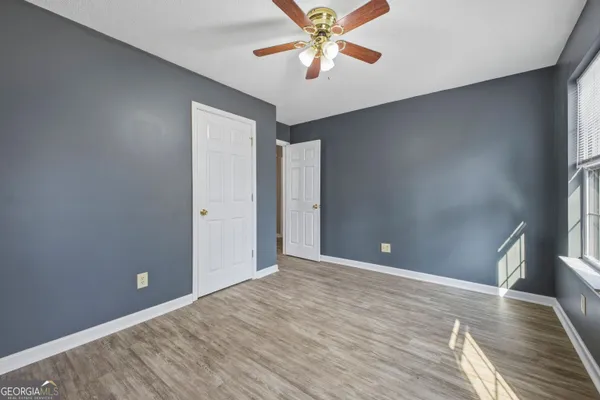 a view of an empty room with window and wooden floor
