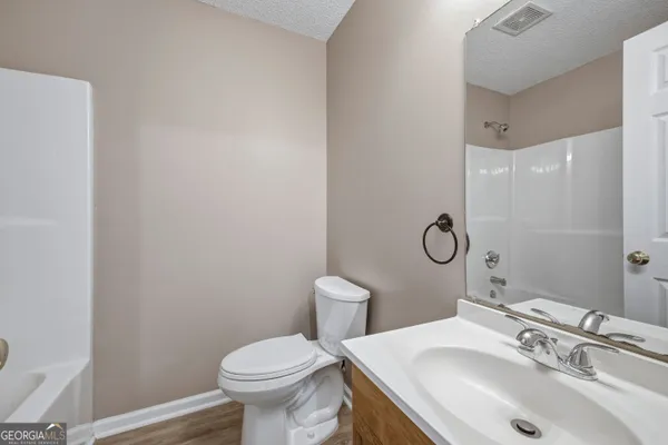 a bathroom with a sink toilet and a mirror