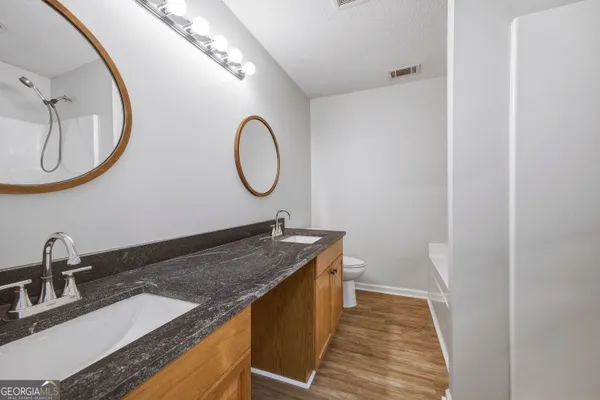a bathroom with a granite countertop sink and a mirror