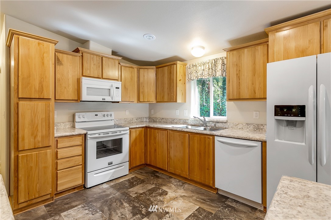 7592 Woodland Road Ferndale, WA 98248 - Photo 11 of 38 a kitchen with stainless steel appliances a stove sink and refrigerator