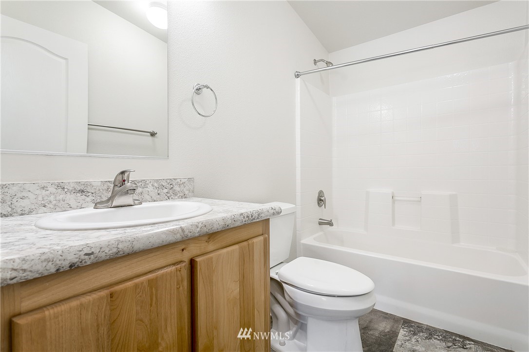 7592 Woodland Road Ferndale, WA 98248 - Photo 16 of 38 a bathroom with a granite countertop sink toilet and shower