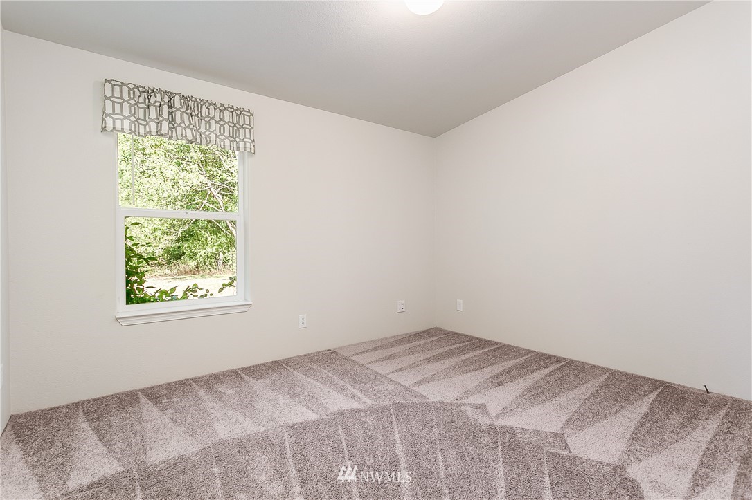 7592 Woodland Road Ferndale, WA 98248 - Photo 21 of 38 a view of a bedroom with wooden floor and a window