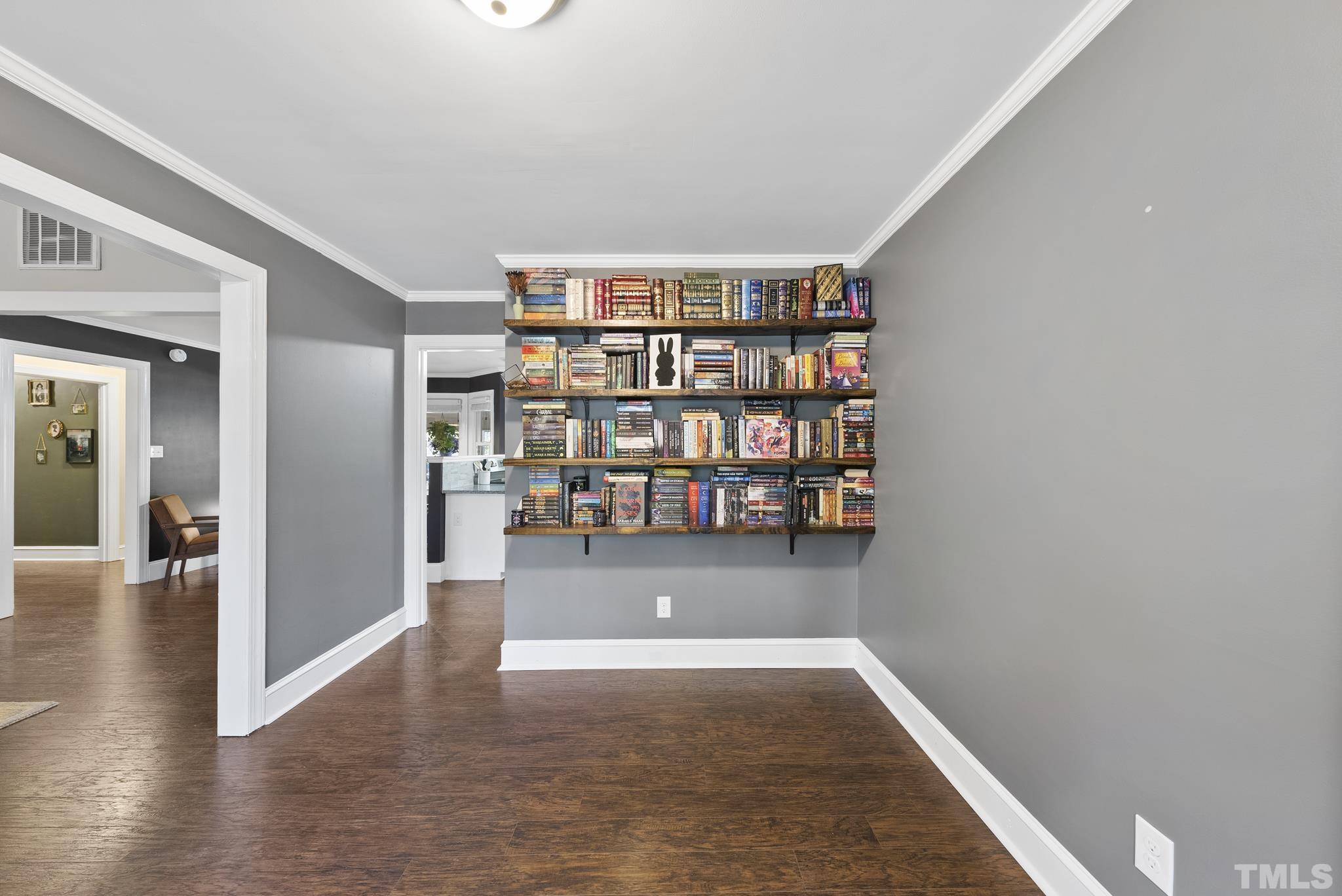 7516 Ray Road Raleigh, NC 27613 - Photo 11 of 23 a view of empty room with wooden floor and book shelf